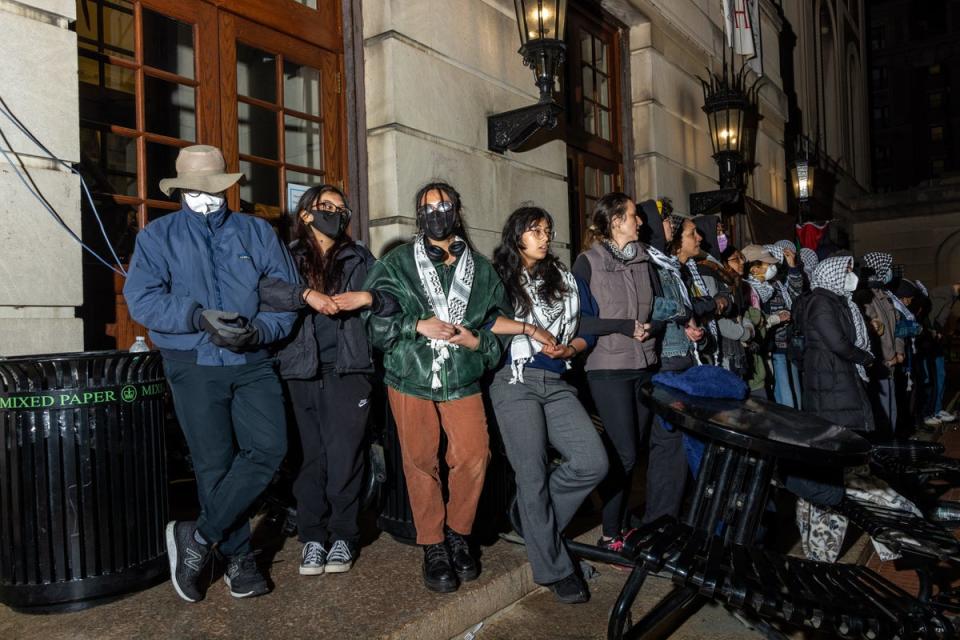 Demonstrators link arms to protect their fellow protestors barricaded inside Hamilton Hall on Tuesday evening (Getty Images)