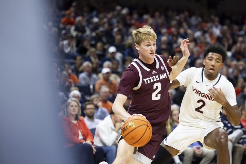 Texas A&M's Hayden Hefner, left, drives past Virginia's Reece Beekman during the first half of an NCAA college basketball game in Charlottesville, Va., Wednesday, Nov. 29, 2023. (AP Photo/Mike Kropf)