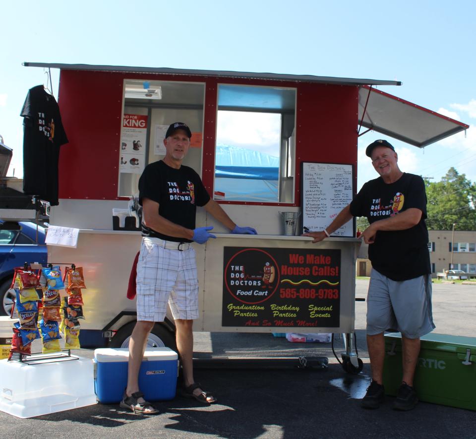 Tim Smith, left, and Thane Graves recently retired from teaching careers at Scio Central School and have launched a new food cart business, The Dog Doctors. The duo set up in Belmont Wednesday.