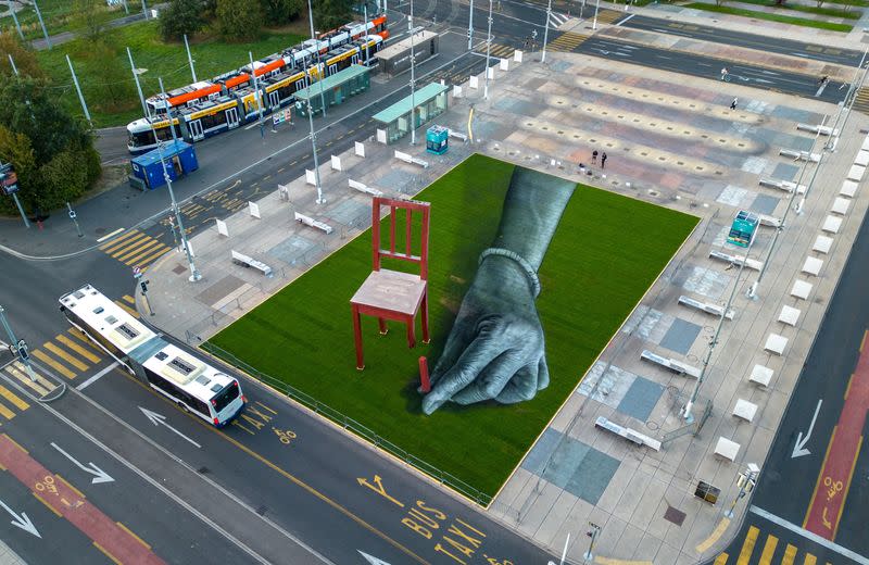 A land art painting called "ALL OF US!" dialogues with the Broken Chair in Geneva