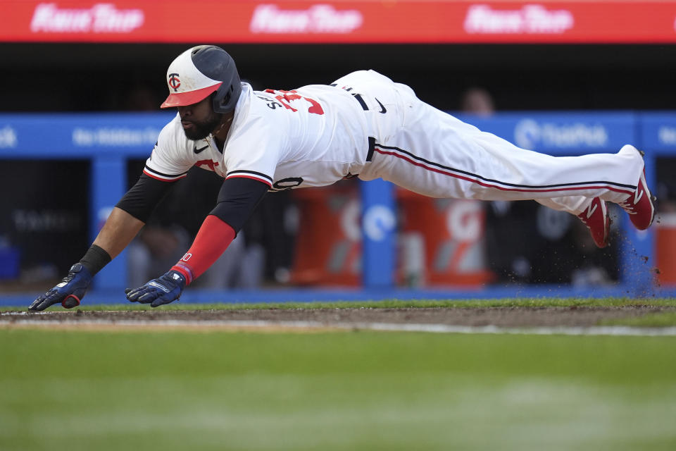 Minnesota Twins' Carlos Santana dives to score against the Chicago White Sox during the second inning of a baseball game Wednesday, April 24, 2024, in Minneapolis. (AP Photo/Abbie Parr)