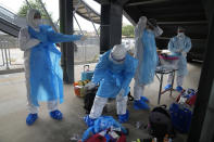 Health workers prepare their protective gear before a group of people infected with COVID-19 arrive at Rangsit train station in Pathum Thani Province, Thailand, Tuesday, July 27, 2021. Thai authorities began transporting some people who have tested positive with the coronavirus from Bangkok to their hometowns on Tuesday for isolation and treatment, to alleviate the burden on the capital’s overwhelmed medical system. (AP Photo/Sakchai Lalit)