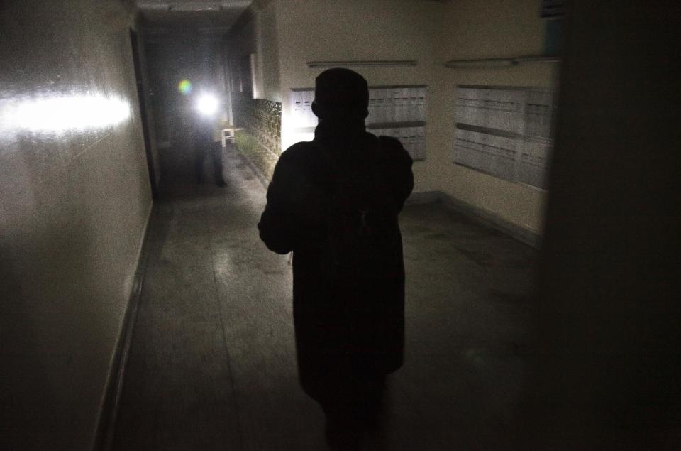 Roxanne Boothe, right, use a flashlight as she walks a hallway at Sam Burt Houses, where she is president of the tenants association, checking residents on Saturday, Nov. 3, 2012 in Coney Island, N.Y. The complex, which has been without power since Monday, flooded during superstorm Sandy and a 90-year-old woman who had lived there for more than 40 years drowned on the first floor. "We have no heat, no water, no electricity, it’s dark in the whole building," said Boothe, frustrated that the Red Cross or FEMA assistance has not reached her neighborhood." (AP Photo/Bebeto Matthews)