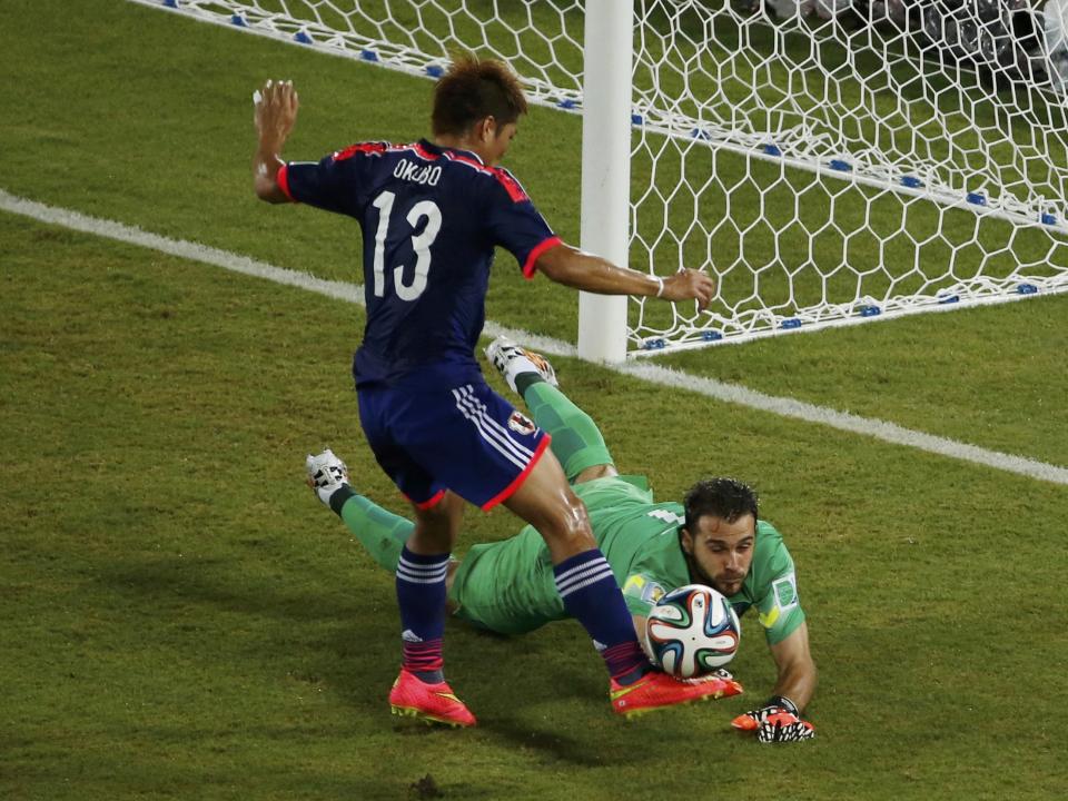 Japan's Yoshito Okubo (L) tries to steal the ball away from Greece's Orestis Karnezis during their 2014 World Cup Group C soccer match at the Dunas arena in Natal June 19, 2014. REUTERS/Carlos Barria