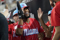 Miami Marlins' Bryan De La Cruz is congratulated in the dugout after scoring on a sacrifice fly by Nick Fortes during the fourth inning of a baseball game against the Milwaukee Brewers, Saturday, Sept. 23, 2023, in Miami. (AP Photo/Lynne Sladky)