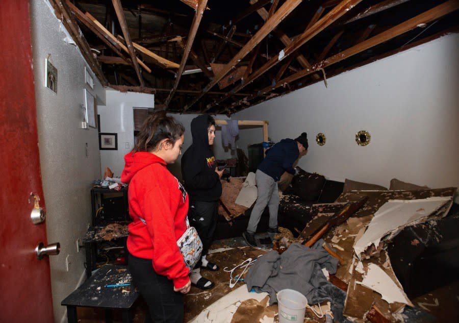 Jorge Amezquita, from right, cousin Adalene Castillo and girlfriend Cassandra Duarte look for a TV remote under debris after a tornado ripped the roof off the apartment on Jan. 24, 2023, at Beamer Place Apartments in Houston. When natural or manmade disasters happen, renters insurance can mean the difference between catastrophe and stability. (Yi-Chin Lee/Houston Chronicle via AP, File)