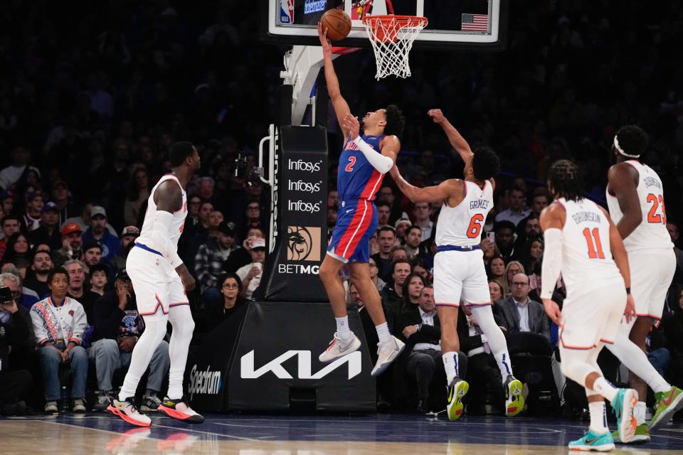 Pistons guard Cade Cunningham, top, makes a basket during the first half on Thursday, Nov. 30, 2023, in New York.