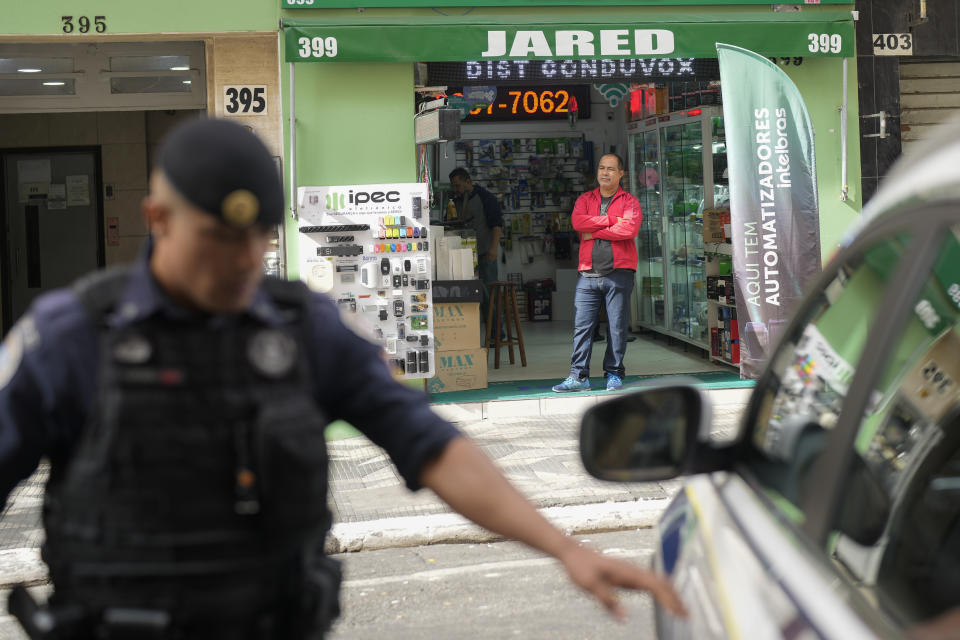 Shop owner Daniel Bonfim stands at the entrance of his store in the Santa Efigenia shopping district, a major commercial hub for electronics, technology products, and accessories, after a police raid against homeless drug users in downtown Sao Paulo, Brazil, Thursday, May 18, 2023. "My entrance door is frequently taken by homeless people and drug addicts, day and night. I have to stand by the door all day long to wait for clients I have had for decades to come near. Now they don't come in, they ask me to go to them." (AP Photo/Andre Penner)