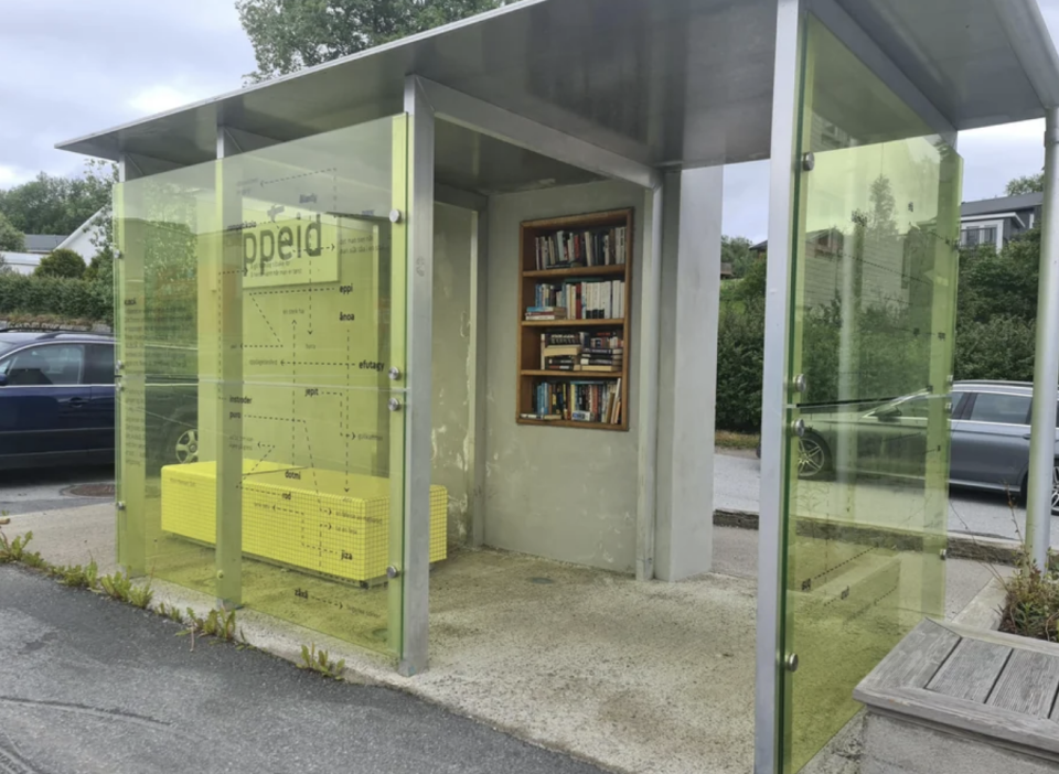 The bus stop is covered, so it's protected from the elements, and has a book shelf filled with books built into the wall