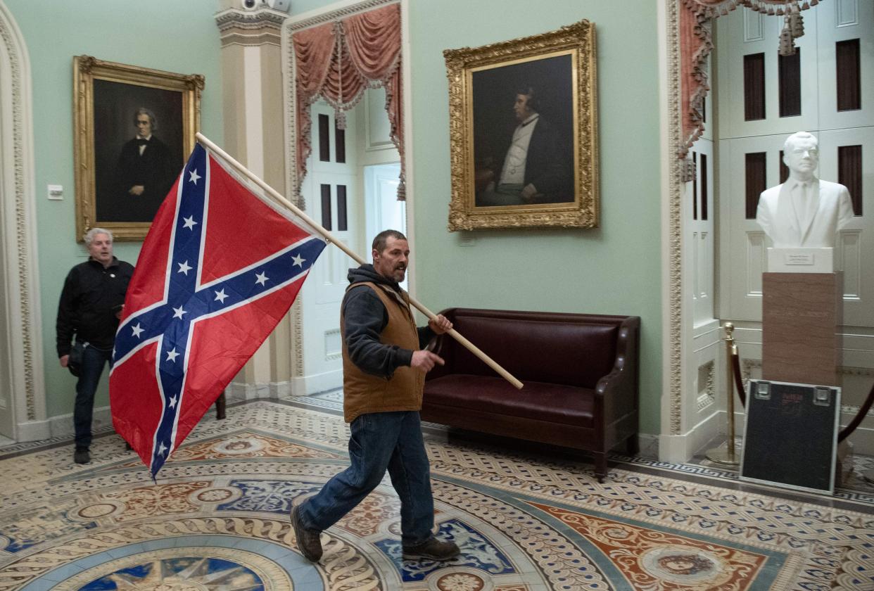 An insurrectionist parades the Confederate battle flag through the U.S. Capitol. (Photo: SAUL LOEB/AFP via Getty Images)