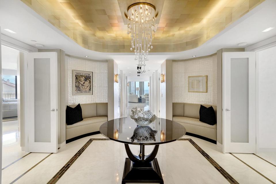 Built-in banquettes and a tray ceiling are part of the condo’s entry hall.