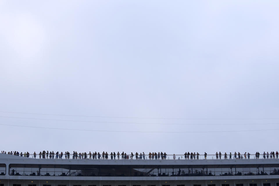 Passengers stand on the deck of the 92,409-ton,16-deck MSC Orchestra cruise ship as it departs from Venice, Italy, Saturday, June 5, 2021. The first cruise ship leaving Venice since the pandemic is set to depart Saturday amid protests by activists demanding that the enormous ships be permanently rerouted out the fragile lagoon, especially Giudecca Canal through the city's historic center, due to environmental and safety risks. (AP Photo/Antonio Calanni)