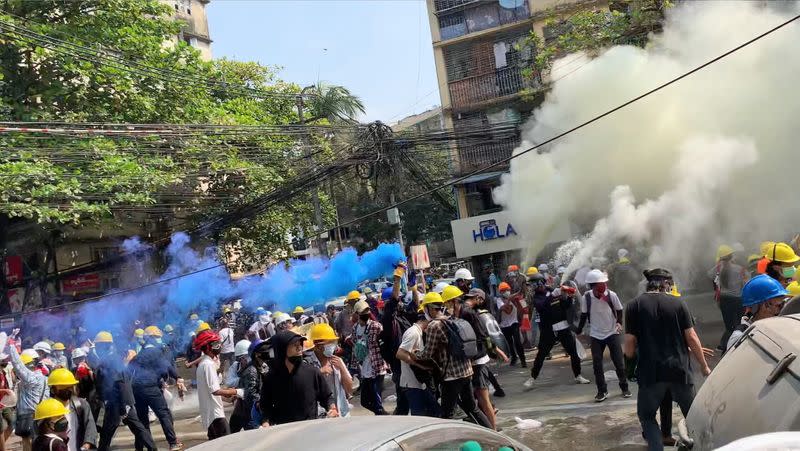 Video grab of protesters setting off smoke grenades to block the view from snipers in Sanchaung, Yangon, Myanmar