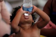 Un niño migrante solicitante de asilo, que fue aprehendido con su madre y devuelto a México bajo el Título 42 después de cruzar la frontera de México a Estados Unidos, bebe agua embotellada en una plaza pública donde cientos de migrantes viven en tiendas de campaña, en Reynosa, México