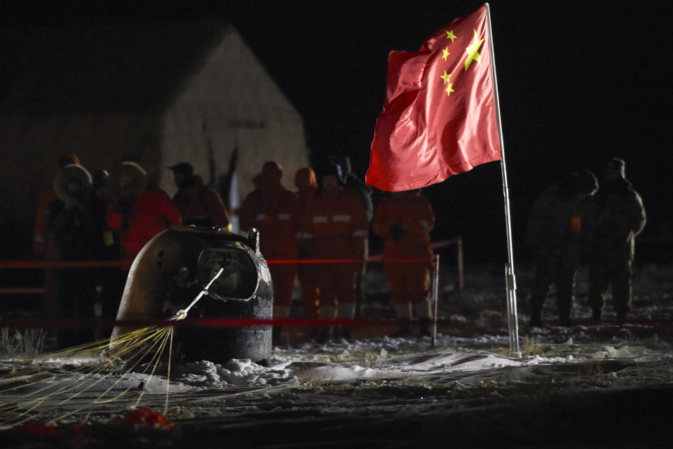 In this photo released by Xinhua News Agency, recovery crews look at the capsule of the Chang'e 5 probe after its successful landing at the main landing site in Siziwang district, north China's Inner Mongolia Autonomous Region on Thursday, Dec. 17, 2020. A Chinese lunar capsule returned to Earth on Thursday with the first fresh samples of rock and debris from the moon in more than 40 years. (Peng Yuan/Xinhua via AP)