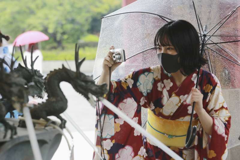 日本這波新冠疫情雖然嚴重，但東京淺草寺仍有許多民眾戴著口罩出遊。（美聯社）