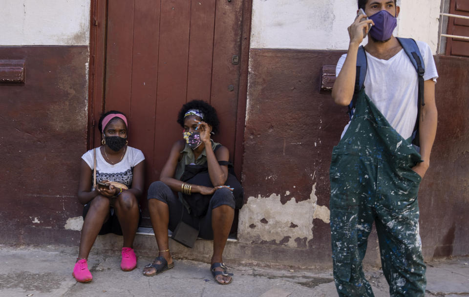People wear masks during the COVID-19 pandemic outside a grocery store where they wait for it to open in Havana, Cuba, Tuesday, Oct. 12, 2021. (AP Photo/Ramon Espinosa)