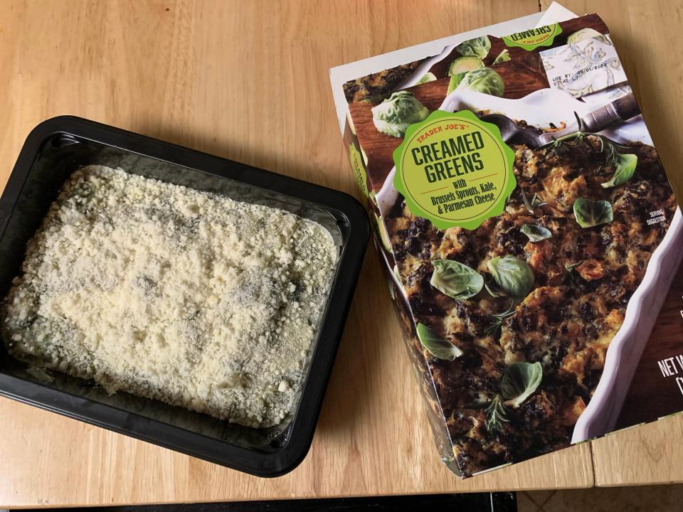 box of Trader joe's creamed greens beside cooked version on wood table