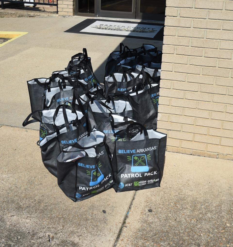 More than a dozen Patrol Packs sit on the sidewalk in front of the Baxter County Sheriff's Office on Thursday. AT&T is providing the food kits to the Sheriff's Office for deputies to hand out while on patrol.