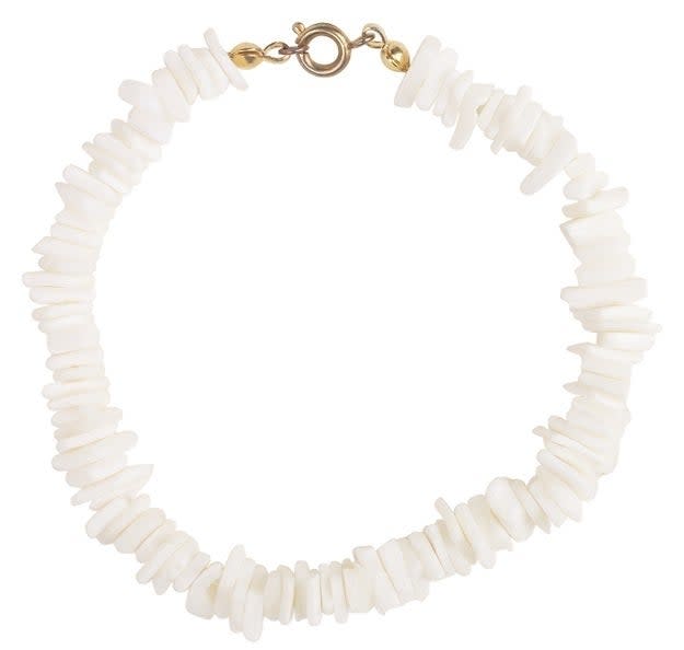 A white shell bracelet with a gold clasp