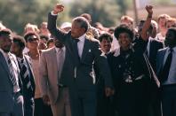 <p>Die südafrikanische Freiheitsikone Nelson Mandela und seine Frau Winnie schreiten nach seiner Haftentlassung am 11. Februar 1990 Hand in Hand und mit gereckter Siegesfaust die Straße entlang. Mandela verbrachte über 27 Jahre im Arrest. (Bild: AP Photo) </p>