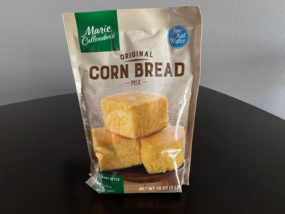 green and beige bag of Marie Callender's cornbread mix on black table