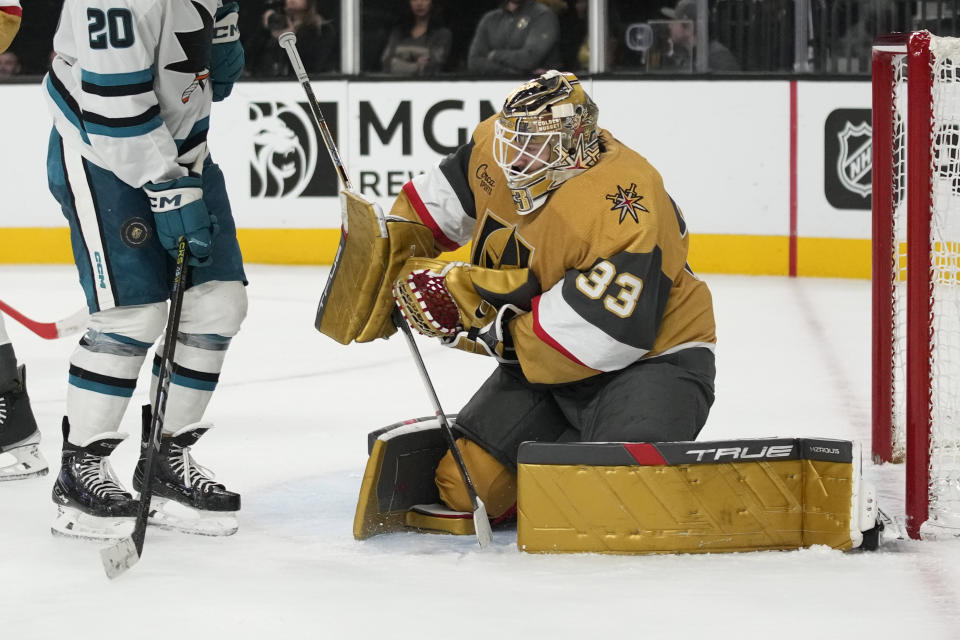 Vegas Golden Knights goaltender Adin Hill (33) makes a save beside San Jose Sharks left wing Fabian Zetterlund (20) during the third period of an NHL hockey game Friday, Nov. 10, 2023, in Las Vegas. (AP Photo/John Locher)