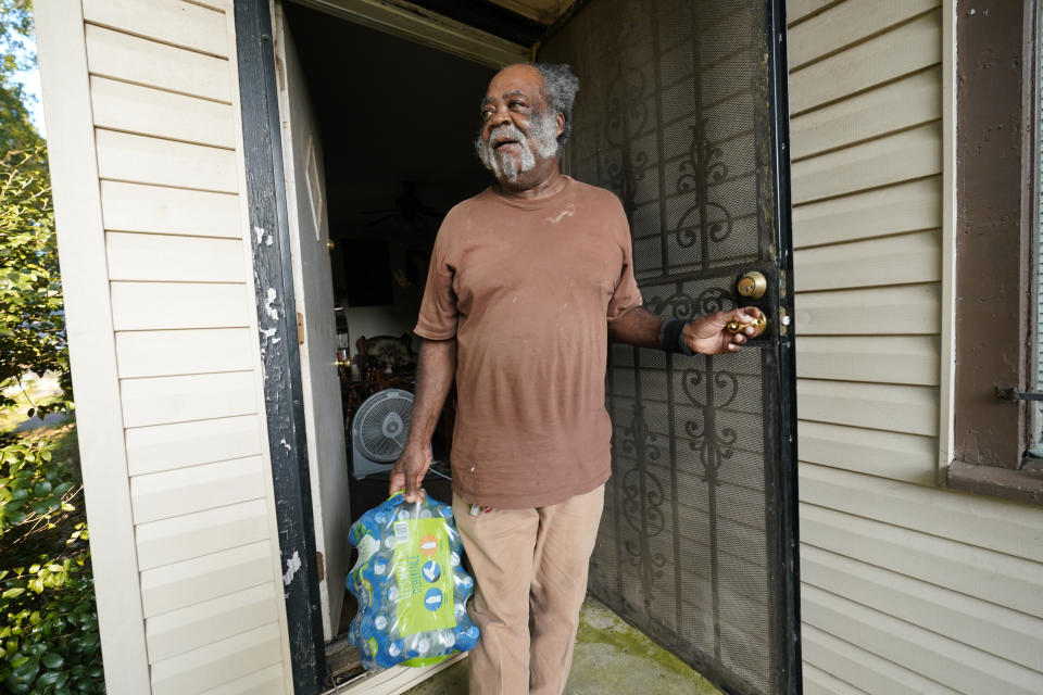 Charles McCaskill, 68, calls out his thanks to members of the Mississippi Students Water Crisis Advocacy team who delivered two cases of water to his south Jackson, Miss., home, on Sept . 7, 2022. A boil-water advisory has been lifted for Mississippi's capital, and the state will stop handing out free bottled water on Saturday. But the crisis isn't over. Water pressure still hasn't been fully restored in Jackson, and some residents say their tap water still comes out looking dirty and smelling like sewage. (AP Photo/Rogelio V. Solis)