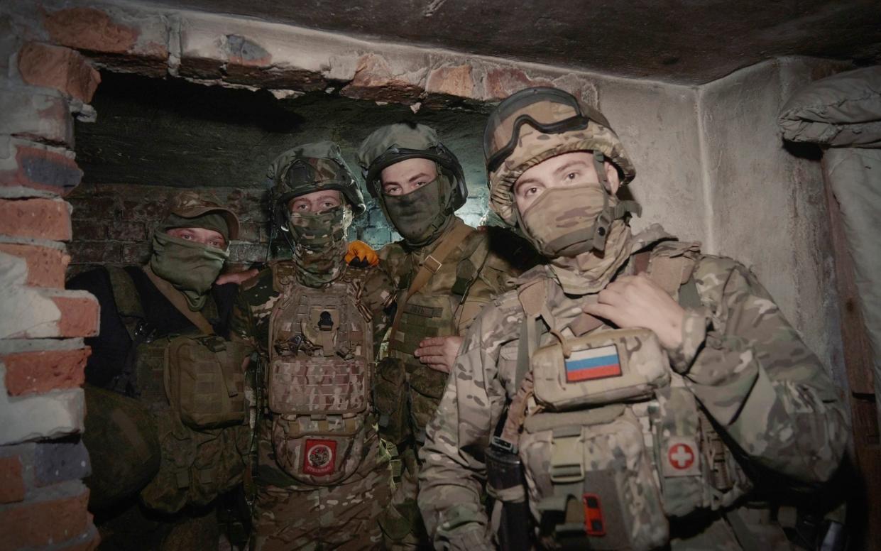 Russian soldiers pose for photo in a shelter at their position in an undisclosed location in Ukraine