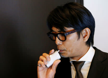 A staff of British American Tobacco Japan demonstrates its new tobacco heating system device 'glo' after a news conference in Tokyo, Japan, November 8, 2016. REUTERS/Kim Kyung-Hoon