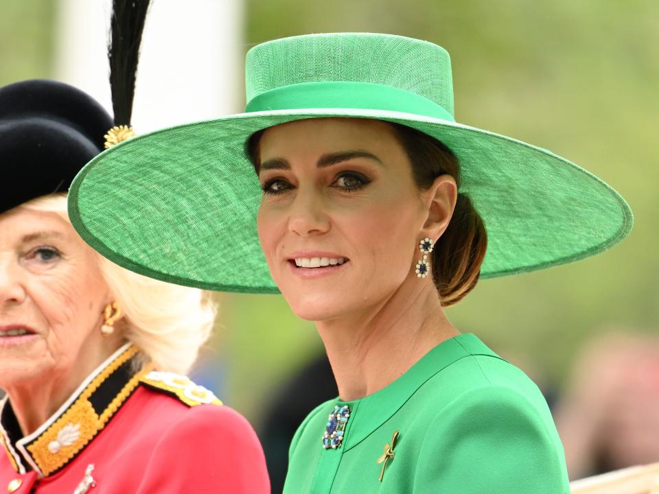 Kate Middleton wears a green coatdress and green hat as she rides in a carriage during the Trooping the Colour parade.