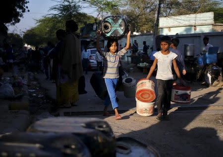 Residents carry empty containers to fill water from a municipal tanker in New Delhi, India, February 21, 2016. REUTERS/Anindito Mukherjee