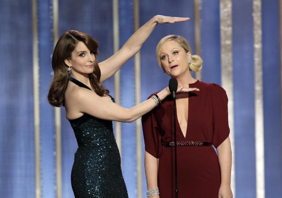 This image released by NBC shows co-hosts Tina Fey, left, and Amy Poehler on stage during the 70th Annual Golden Globe Awards held at the Beverly Hilton Hotel on Sunday, Jan. 13, 2013, in Beverly Hills, Calif. (AP Photo/NBC, Paul Drinkwater)