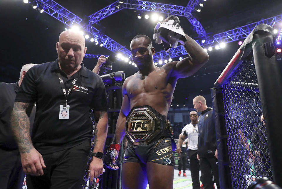 Leon Edwards, right, leaves the Octagon after victory against Kamaru Usman after their welterweight title bout at the UFC 286 mixed martial event at O2 Arena, in London, Saturday, March 18, 2023. (Kieran Cleeves/PA via AP)