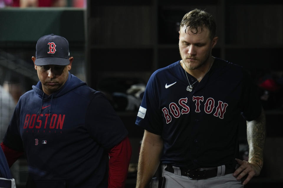 Boston Red Sox starting pitcher Tanner Houck, right, stands in the dugout with manager Alex Cora after being pulled from the mound for a reliever during the fifth inning of a baseball game against the Texas Rangers, Tuesday, Sept. 19, 2023, in Arlington, Texas. (AP Photo/Julio Cortez)