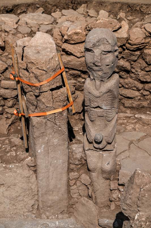 A photograph taken at the archaeological site of Karahantepe in Sanliurfa, southeastern Turkey on October 9, 2023, shows a newly found 2.3-meter high human statue (R), a stone man seated, clutching his sex with both hands, a vulture at his feet on the wall of a room. On this archaeological site, a stone statue, over 2.30 m high and seated on a bench adorned with a leopard, was discovered at the end of September in south-east Turkey, at the heart of a complex of some twenty sites that were home to thousands of humans during the Stone Age, twelve thousand years ago.<p>OZAN KOSE/Getty Images</p>