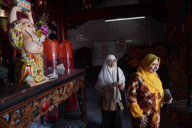 Muslim women Widi Astuti (L) and Lusi Kusuma visit a Buddhist temple in the Indonesian capital city of Jakarta, on February 8, 2013 as minority Chinese-Indonesians celebrate the Lunar New Year. As Indonesia and other countries with Chinese diasporas welcome the Year of the Snake, hardline Islamic leaders have ignited a religious row by declaring the celebrations 'haram' and off limits for Muslims