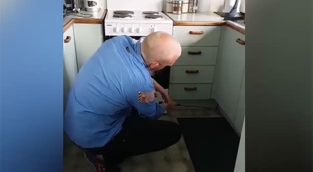 The small snake squeezed in under the kitchen cabinets. Source: Storyful