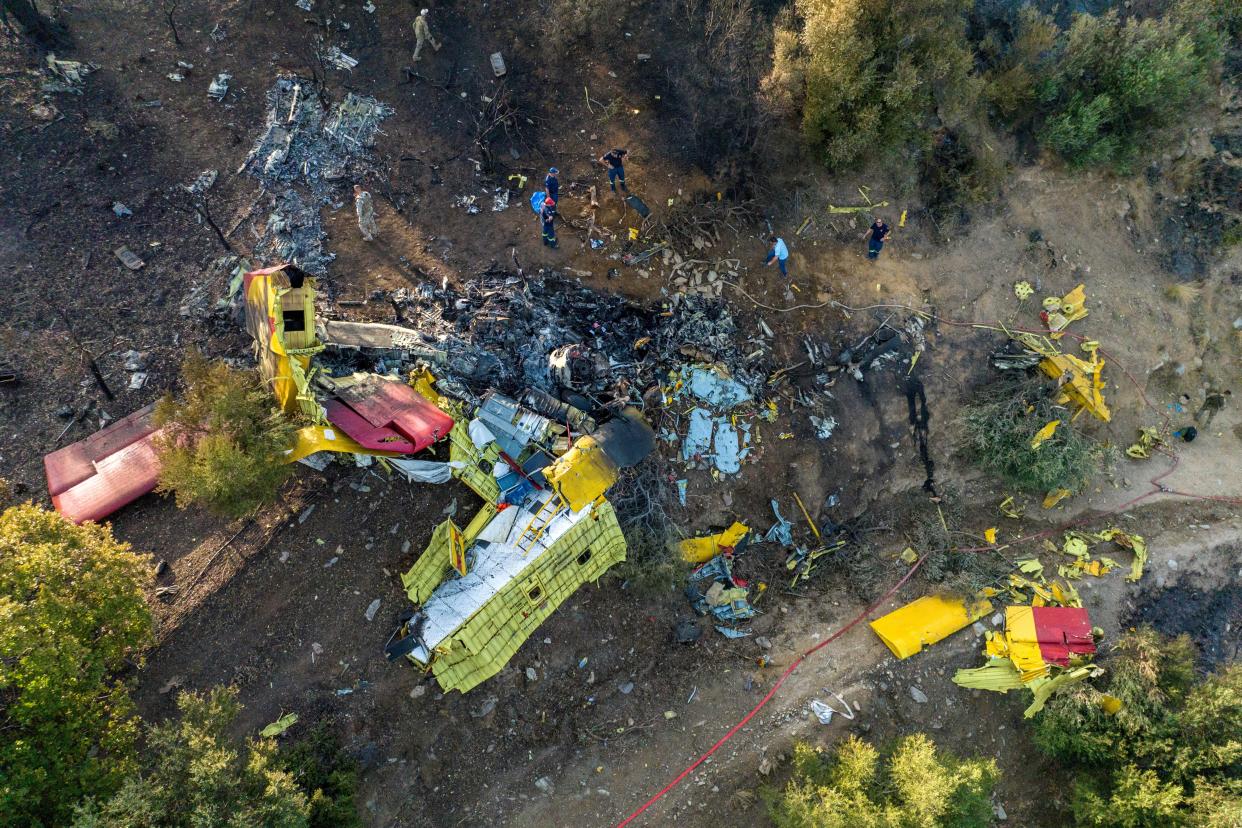 Rescuers operate at the site where a firefighting plane crashed after a water drop as a wildfire burns in Karystos on the island of Evia, Greece (REUTERS)