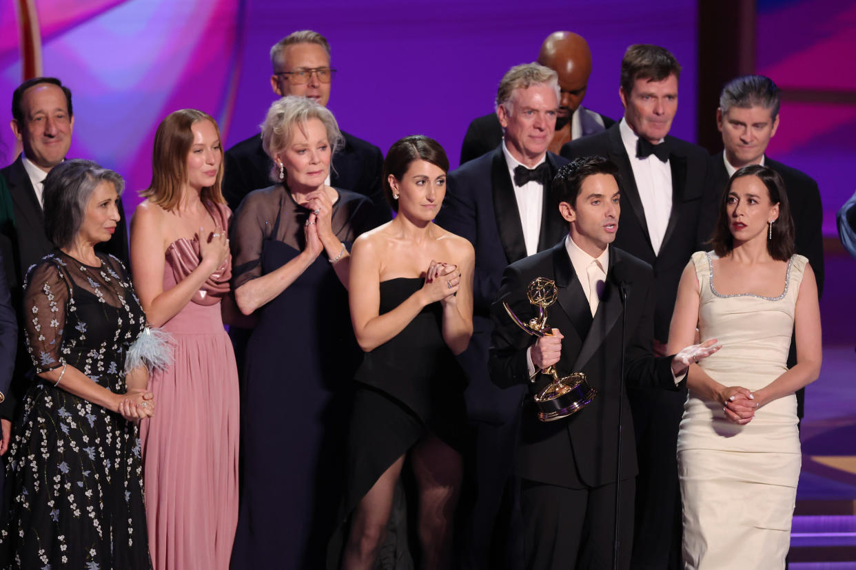 Hacks cast and crew onstage including David Miner, Rose Abdoo, Hannah Einbinder, Nate Young, Jean Smart, Jen Statsky, Christopher McDonald, Paul W. Downs and Lucia Aniello.