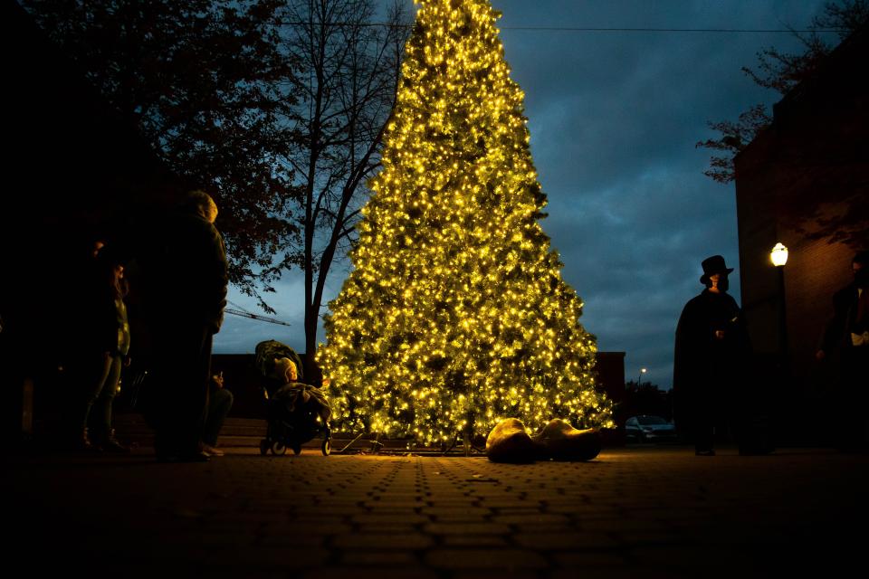 Families take photos next to Holland's new Christmas tree during the Holiday Open House on Saturday, Nov. 20, 2021.