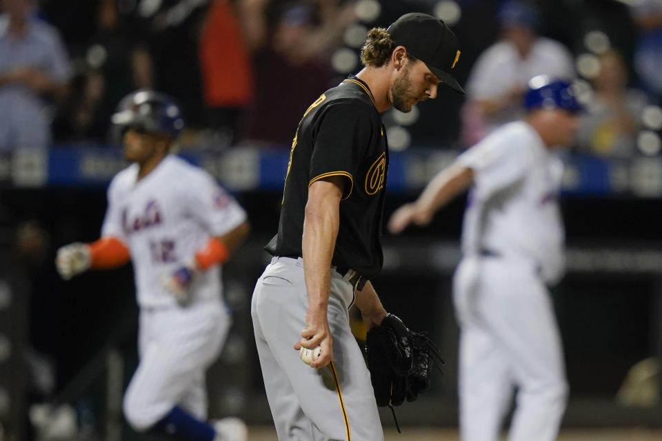 Pittsburgh Pirates relief pitcher Kyle Keller, center, reacts as New York Mets' Francisco Lindor, left, runs the bases after hitting a grand slam during the sixth inning of a baseball game Friday, July 9, 2021, in New York. (AP Photo/Frank Franklin II)