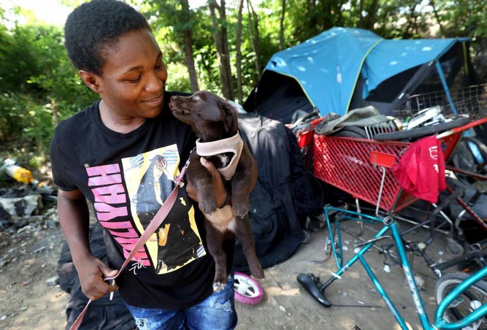 Maxine Owens gives kisses to her new puppy on Thursday, July 6, 2023. Owens was matched with an assistance program that will help pay her rent for at least three months, allowing her to escape Texas’ dangerous heat.