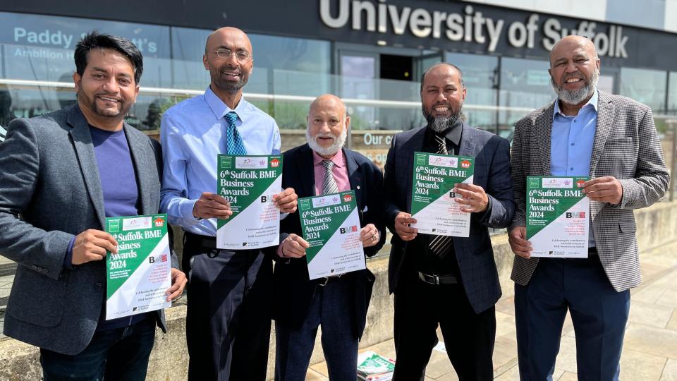 Five men of Bangladeshi origin hold A4 posters promoting an awards event