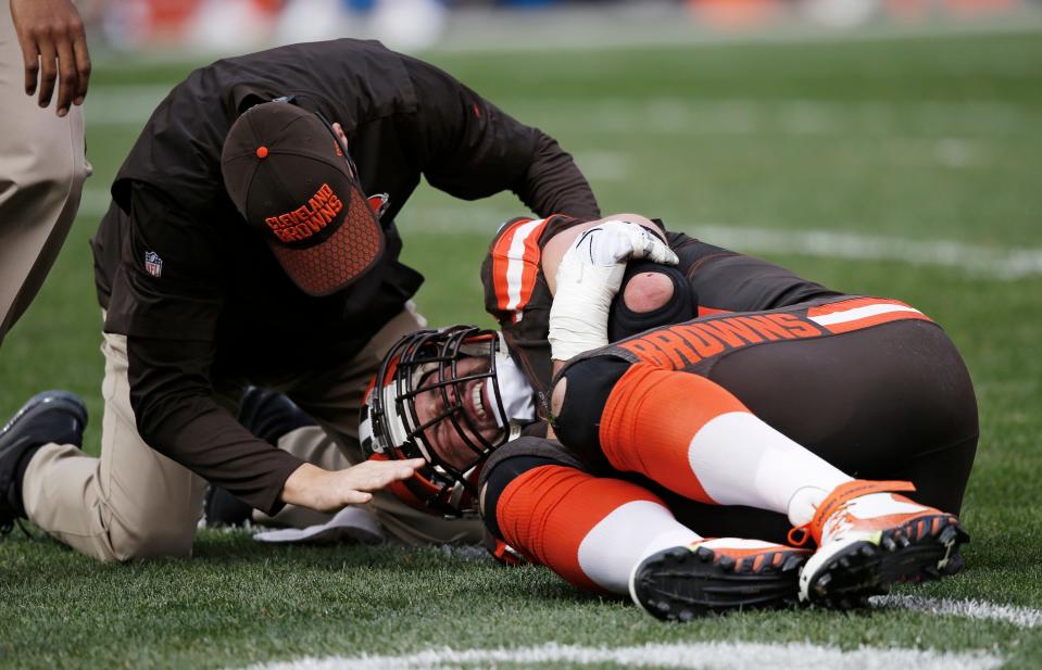 Cleveland Browns tackle Joe Thomas is checked by a team trainer after Thomas was hurt in a game Oct. 22, 2017, against the Tennessee Titans, in Cleveland.