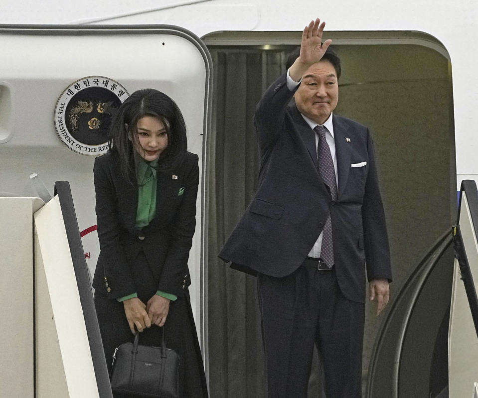 South Korean President Yoon Suk Yeol, right, with his wife Kim Keon Hee, waves at Haneda International Airport on his departure for South Korea, in Tokyo, Friday, March 17, 2023. (Yuya Shino/Kyodo News via AP)