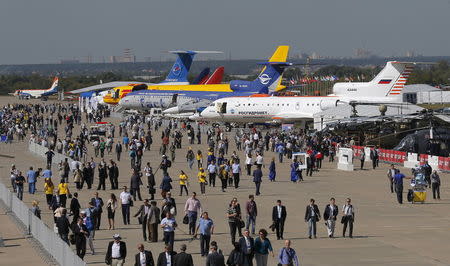 Visitors walk along a row of planes and helicopters on display at the MAKS International Aviation and Space Salon in Zhukovsky, outside Moscow, Russia, August 25, 2015. REUTERS/Maxim Shemetov