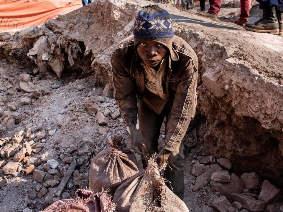 A miner ties together bags of cobalt at a mine in Congo