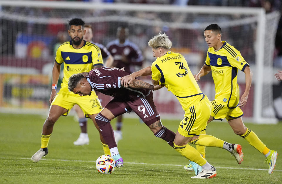 Colorado Rapids forward Rafael Navarro, front left, drives past Nashville SC defender Lukas MacNaughton, front right, as Nashville midfielder Anibal Godoy, back left, and forward Jacob Shaffelburg, right, trail the play during the first half of an MLS soccer match Saturday, March 2, 2024, in Commerce City, Colo. (AP Photo/David Zalubowski)