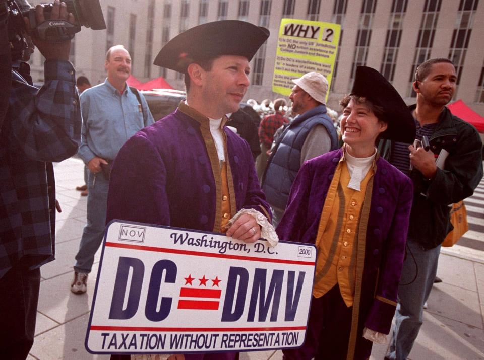 Mark Phillips, left, and Karen Beriss show off the new District of Columbia license plate at a rally for the new "Taxation Without Representation" on Nov. 4, 2000.